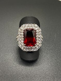 Amazing Cocktail Statement Ring.  Ring made of 925 Sterling silver holds 66 prong set cubic Zirconia that surround a 15 X 10 mm red CZ.   Say wow with sparkle and add a little shizam to your ensemble! Size 7 Grab this beauty today!! Comes in a black ring box Dazzling Party Rings With Prong Setting, Dazzling Party Rings With Sparkling Stones, Dazzling Party Crystal Ring With Center Stone, Sparkling Crystal Rings For Party, White Gold Rings With Sparkling Stones For Party, Gift Crystal Rings With Sparkling Stones, Formal Crystal Ring With Sparkling Stones, Dazzling Crystal Gemstone Ring For Parties, Diamond Rings For Party With Emerald Cut