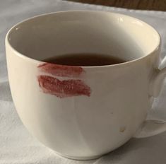 a white cup filled with liquid on top of a table