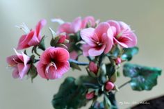 pink flowers are in a green vase on a table