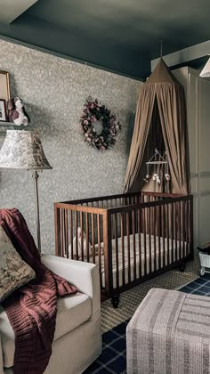 a baby's room with a crib, chair and ottoman