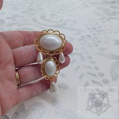 An exclusive statement piece, the "Anne" Brooch is intricately crafted with Renaissance flair. Featuring a unique combination of pearl, colorful stones, and a timeless gold frame, its charm is perfect for elevating any look. Adorn yourself in style and sophistication with this luxurious brooch.2.5" in length, perfect to adorn a bodice, hat, or bag! White Brooch Jewelry For Evening, White Evening Jewelry With Brooch, Elegant Metal Brooches For Parties, Elegant Baroque Wedding Brooches, White Ornate Brooch For Formal Occasions, Elegant Wedding Brooch With Cabochon Detail, White Ornate Brooches For Formal Occasions, Elegant Metal Brooches As Gift, Ornate White Brooches For Formal Occasions