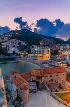 an aerial view of the city and its bay at sunset, with clouds in the sky