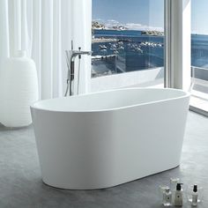 a white bath tub sitting on top of a bathroom floor next to a large window