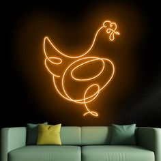 a living room with a couch and a neon chicken wall decal