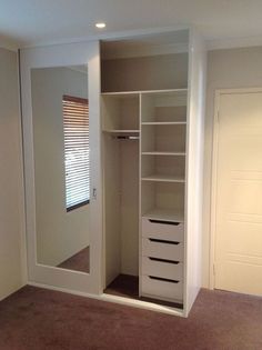 an empty walk in closet with white drawers