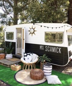 a camper parked on top of a lush green field next to a picnic table