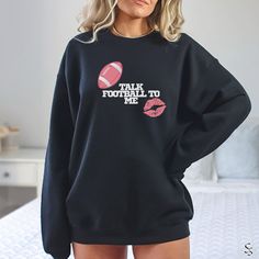 Calling all football fans! This comfy sweatshirt is the ultimate way to show your love for the game on game day or any day. Whether you're a cheering on your favorite team, a dedicated football mom, or a football enthusiast, this sweatshirt is for you! This design is perfect for: *Football Moms: Show your team spirit and celebrate football season in style. *Women Football Fans: Represent your passion for the game in a comfortable and fun way. *Girlfriend Gift: Surprise your football-loving girlf Fleece Tops With Letter Print For Fans, Game Day Football Season Crew Neck Sweatshirt, Game Day Fan Apparel Long Sleeve Sweatshirt, Football Season Game Day Crew Neck Sweatshirt, Sports Fan Long Sleeve Fleece Sweatshirt, Fleece Long Sleeve Sports Fan Sweatshirt, Game Day Football Season Sweatshirt With Letter Print, Game Day Fleece Sweatshirt With Graphic Print, Football Season Sweatshirt With Letter Print For Game Day