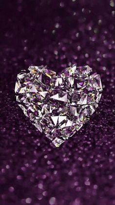 a heart shaped diamond sitting on top of a purple surface