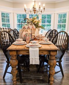 the dining room table is set with dishes and place settings