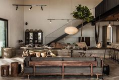 a living room filled with furniture next to a staircase leading up to a second story