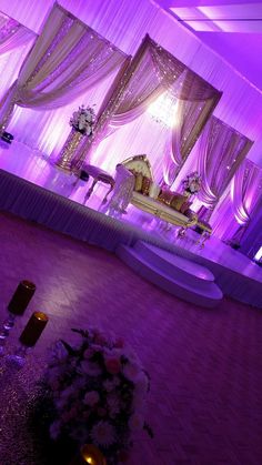 a purple and white wedding setup with candles