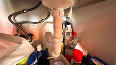 a bathroom sink filled with lots of clutter and cleaning supplies next to a faucet