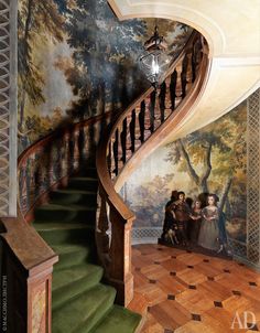 an ornate staircase leading up to a painting on the wall