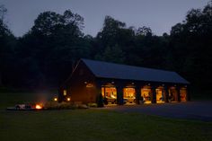 a small cabin lit up at night with lights on the front and side doors open