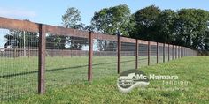 a fence that is in the grass near some trees