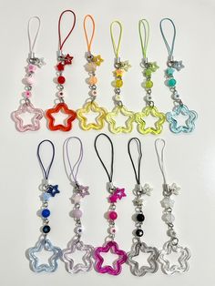 many different colored charms are hanging on a white surface with one star in the middle