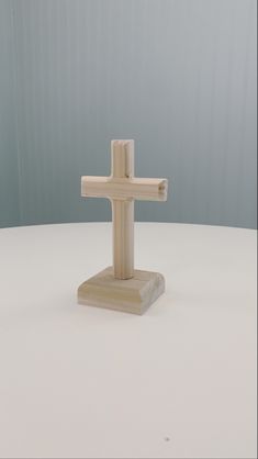 a wooden cross sitting on top of a white table