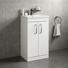 a bathroom with a sink, mirror and towel rack in it's corner on the wall