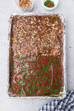 a chocolate cake with sprinkles and nuts on top