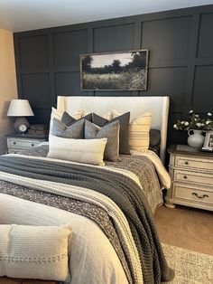 a bedroom with a bed, nightstands and pictures on the wall above it is decorated in neutral colors