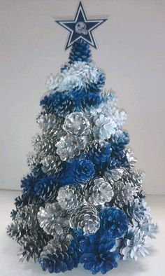 a blue and silver christmas tree with a star on it's top is shown in front of a white background