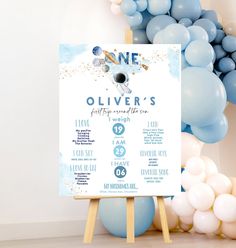 a baby shower sign sitting on top of a wooden easer next to blue and white balloons