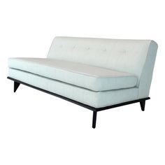 a white couch sitting on top of a wooden frame