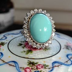 Size: 5 US 49 EU (FREE RESIZING) Metal Type: 18k white gold Weight: 16.6 grams Diamonds weight: 1.20 ct. Color:H Clarity: VSI Natural turquoise: 15mm x 19mm Condition: excellent  Introducing our Vintage 1960s sky blue turquoise and 1.20 ct. Diamond 18k Solid White Gold Statement Ring- a perfect blend of vintage charm and modern elegance. This ring is meticulously crafted from 18k solid white gold, ensuring a timeless appeal and lasting durability. The ring features a beautiful soft blue turquoise at their center, adding a touch of natural beauty and sophistication to the piece. Surrounding the stone is a halo of sparkling altogether 1.20 ct. diamonds, adding a touch of luxury and brilliance to the ring. These diamonds are carefully set to catch the light from every angle, making the ring s Formal Turquoise Diamond Ring With Gemstone, Formal Turquoise Diamond Ring, Formal Fine Jewelry Turquoise Diamond Ring, Elegant Turquoise Gemstone Ring For Formal Occasions, Turquoise Diamond Ring With Center Stone, Fine Jewelry Turquoise Diamond Ring, Formal Oval Turquoise Ring With Diamond, Elegant Turquoise Diamond Ring, Oval Diamond Turquoise Ring For Formal Occasions