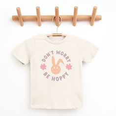 Looking for a cute tee for your kids? We have the perfect Don't Worry Be Hoppy Bunny graphic tee addition to their closet! Also available in toddler tees. Playful Cartoon Print T-shirt For Spring, Playful Spring T-shirt With Funny Print, Playful Screen Print Tops For Spring, Playful Spring Screen Print Tops, Playful Spring T-shirt With Text Print, Playful Slogan T-shirt For Spring, Playful Spring Top With Text Print, Bunny Graphic, Toddler Tees