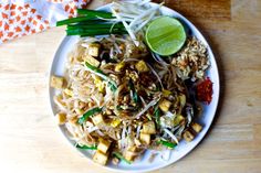 a white plate topped with rice and veggies on top of a wooden table