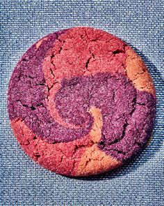 a red and purple cookie sitting on top of a blue cloth