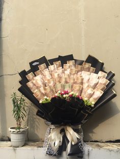 a bouquet of flowers sitting on top of a window sill next to a potted plant