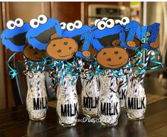 there are some cookies and candy in the vases with blue decorations on them that look like sesame street characters