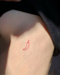 a small red chili pepper tattoo on the back of a woman's left thigh