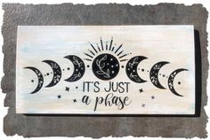 a wooden sign that says it's just a phase with three phases in the sky