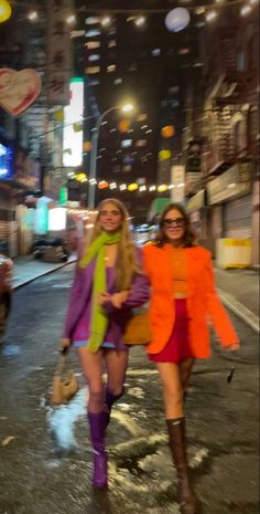 two women walking down the street at night