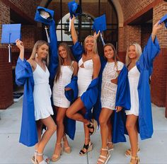 four women in graduation gowns posing for the camera