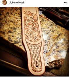 an intricately carved wooden instrument case sitting on top of a granite counter next to a piece of wood