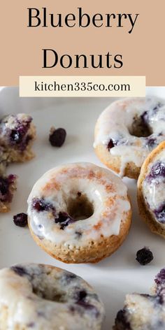 blueberry donuts with icing and raisins are on a white plate