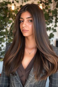 Woman with long, straight dark brown hair and a dramatic center part. Polished Look, Sleek