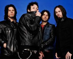 three men standing next to each other in front of a blue background wearing black leather jackets