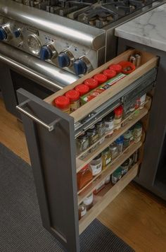 an open drawer in the middle of a kitchen with spices and condiments on it