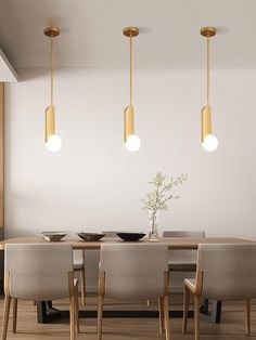 a dining room table with four lights hanging over it