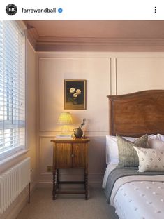 a bed room with a neatly made bed and a night stand next to the window