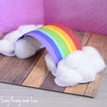 a rainbow made out of cotton sitting on top of a wooden board