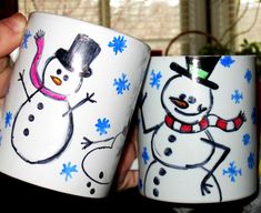 two coffee mugs with snowmen painted on them