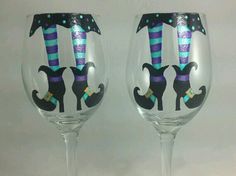 two wine glasses with designs on them sitting next to each other