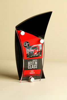 an award for best in class trucking is displayed on a white surface with black and red accents