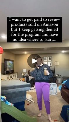 a woman standing in a living room holding a cup