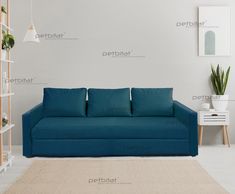 a blue couch sitting on top of a white floor next to a potted plant